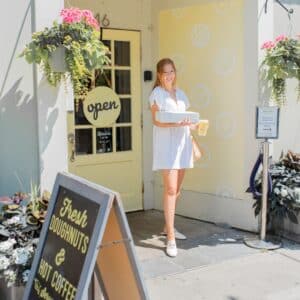 Girl buying doughnuts in front of yellow building at Young Bun's