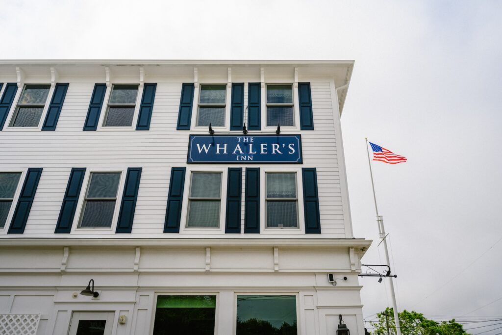 The exterior of one of the best Mystic, Connecticut, hotels, featuring a white building with navy shutters.