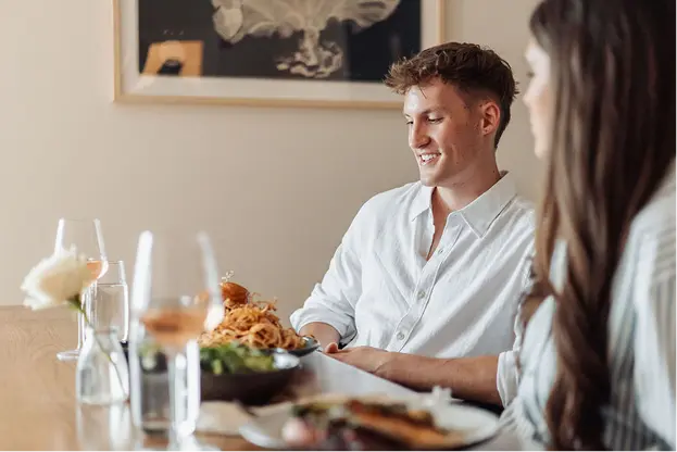 Young couple enjoying a pleasant dinner together at a restaurant with wine and appetizers.