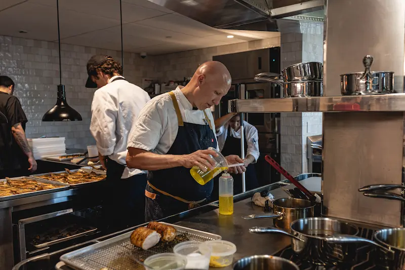 Professional chefs preparing food in a busy, modern commercial kitchen.