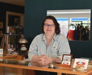 Picture of Lilian Rodger's posing behind desk while giving sustainable shopping tips in Mystic
