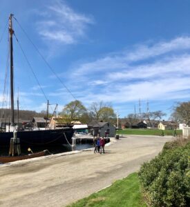 The Mystic Seaport Museum Village with a tall ship to the left. 