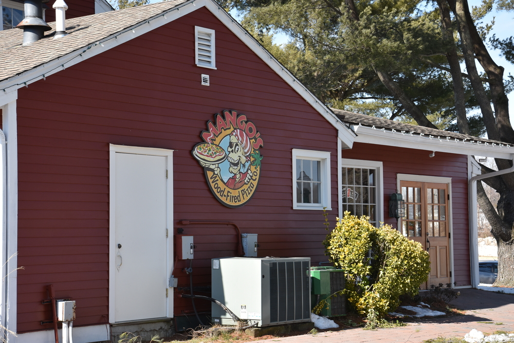 Exterior of Mango's Wood-Fired Pizza Co. restaurant featuring a pirate-themed logo on a red building.