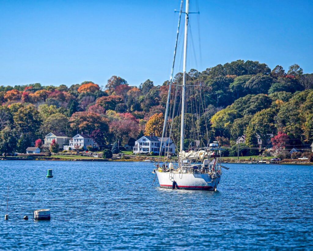 Fall foliage surrounding the water with a boat during a weekend getaway in New England.